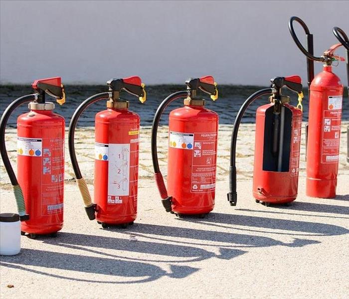 A lineup of different fire extinguishers.